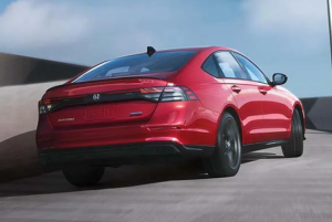 A red 2024 Honda Accord driving down a concrete road near Orangeburg, South Carolina