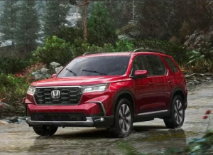 A red 2024 Honda Pilot driving through a muddy dirt road in the rain near Orangeburg, South Carolina