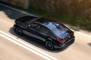 A black 2025 Honda Civic driving down a sunlit road near Orangeburg, South Carolina