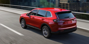A red 2025 Honda CR-V driving down a city road near Orangeburg, South Carolina